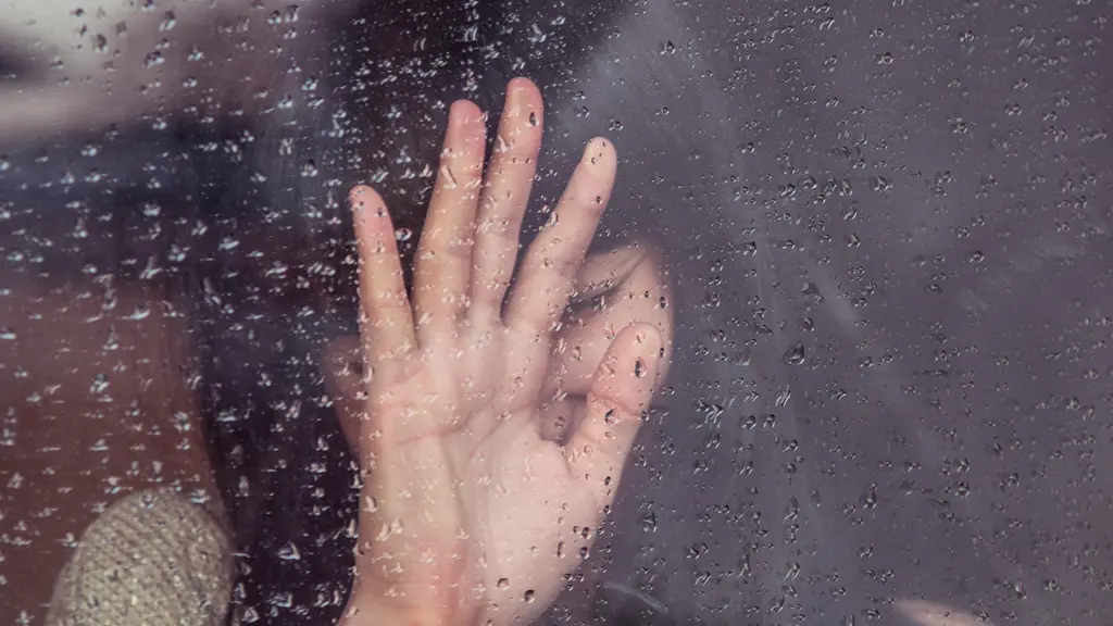 Raindrops streaking down a clear glass window surface representing acknowledging and releasing sorrow